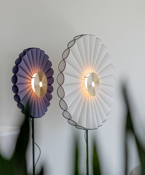 Zwei dekorative Stehlampen in Blütenform leuchten warm vor einer hellen Wand.