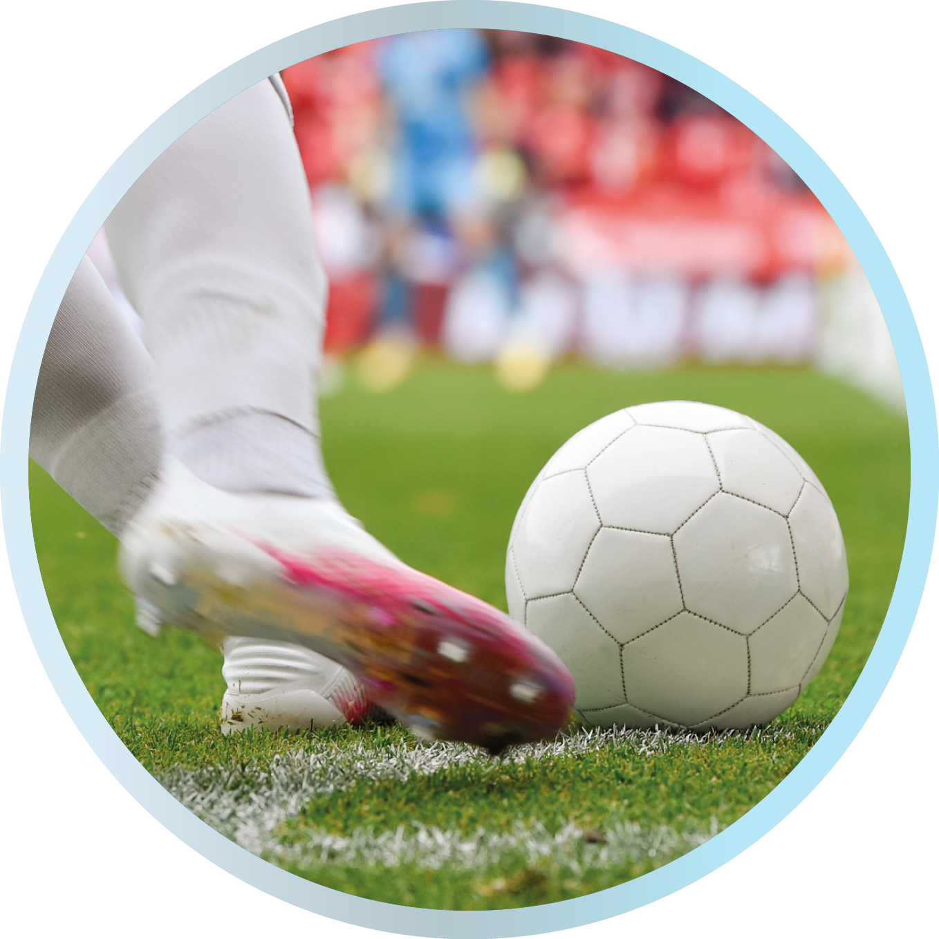 Ein Fußballer in weißen Stutzen setzt zum Schuss an und trifft den Ball auf dem grünen Spielfeld.